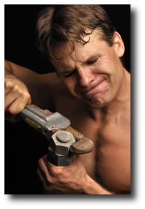 man with wrench struggling with a nut